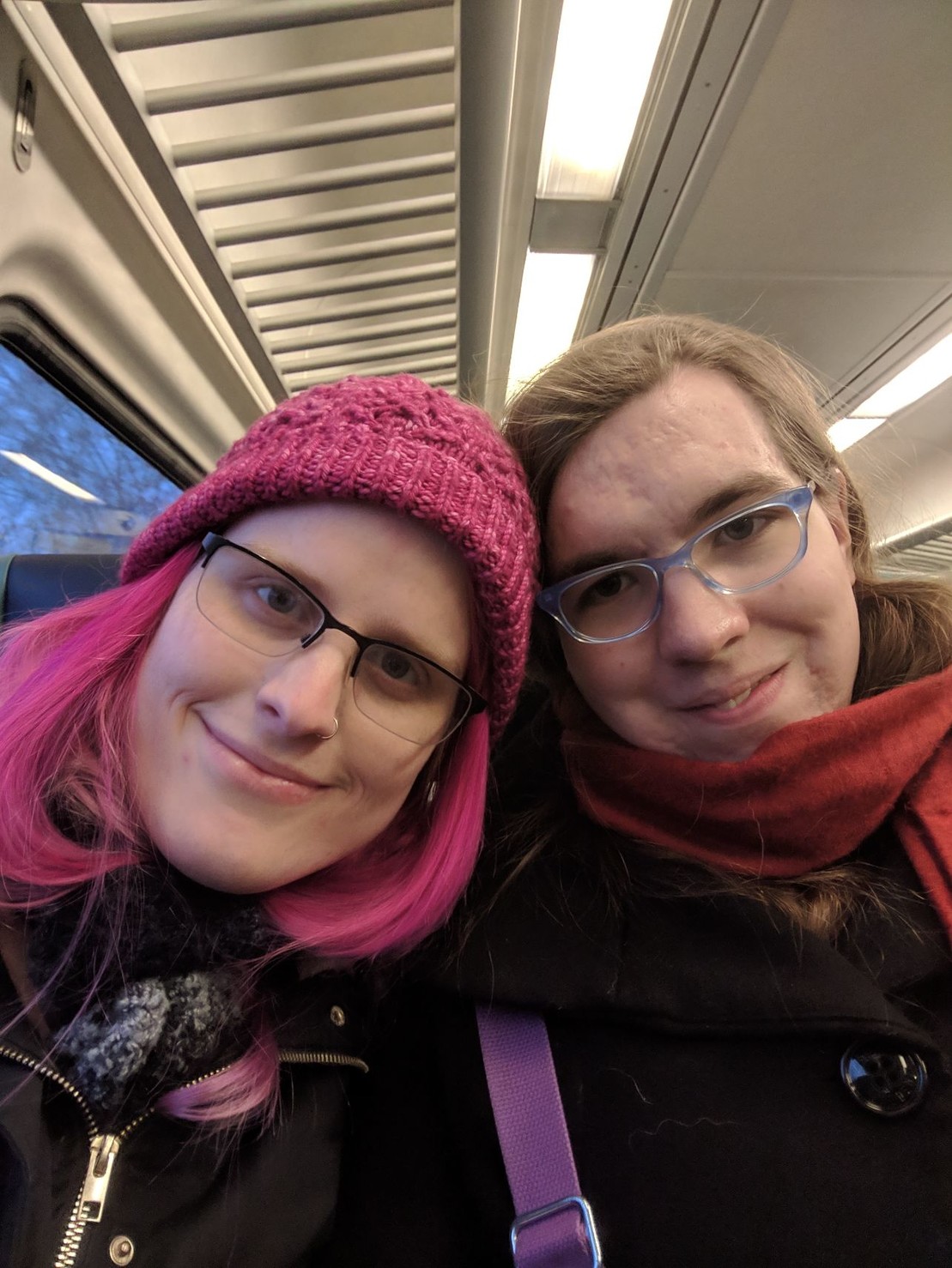 two smiling women on a train