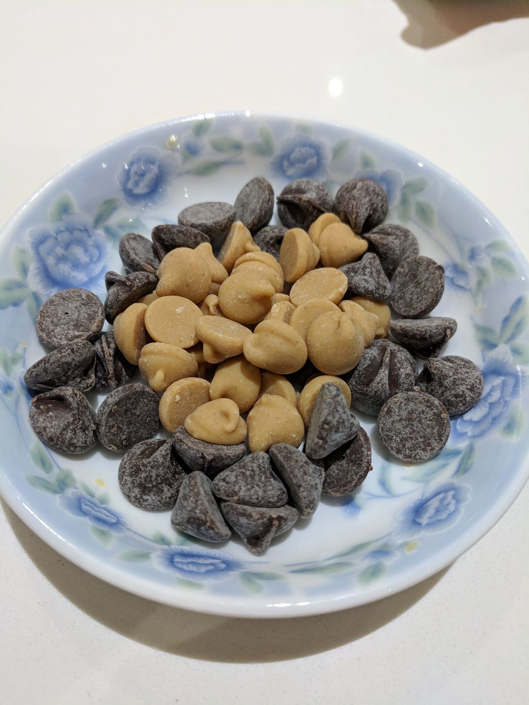 a small dish filled with peanut butter chips and chocolate chips.