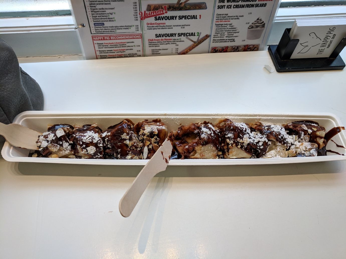 a long rolled up pancake covered in chocolate sauce