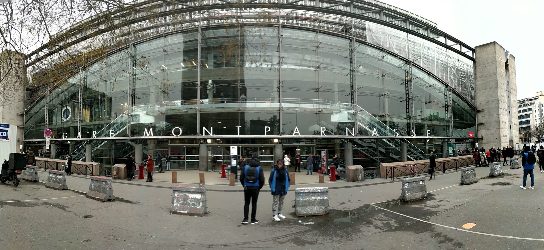 a modern glass entryway covering a brutalist concere façade