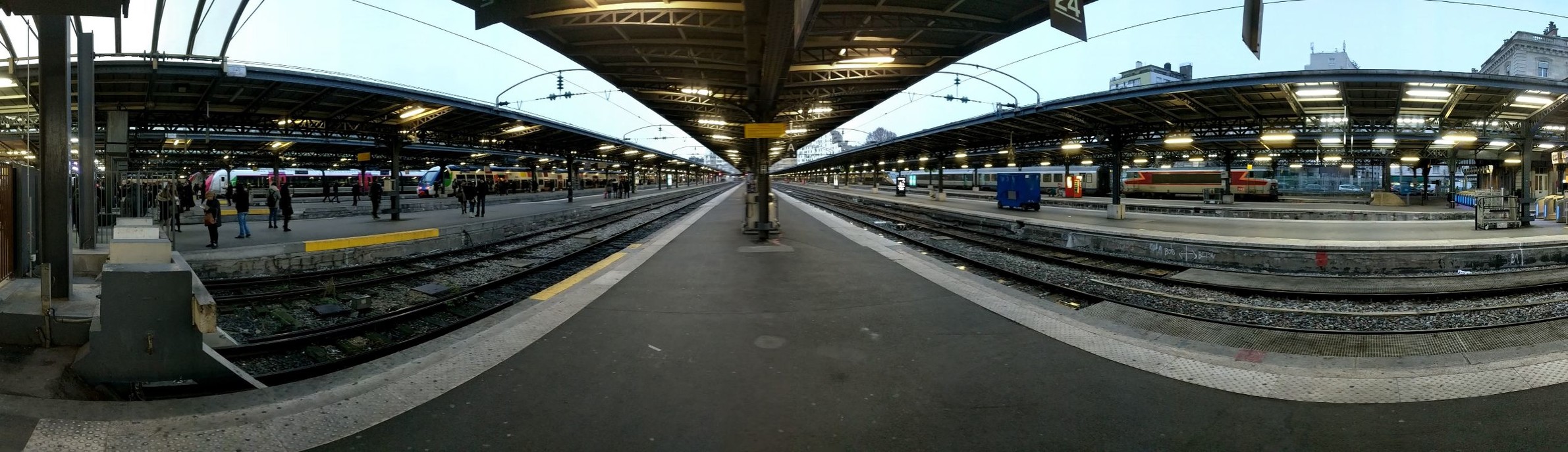 a panoti  view of an outdoor station with awnings above the platform