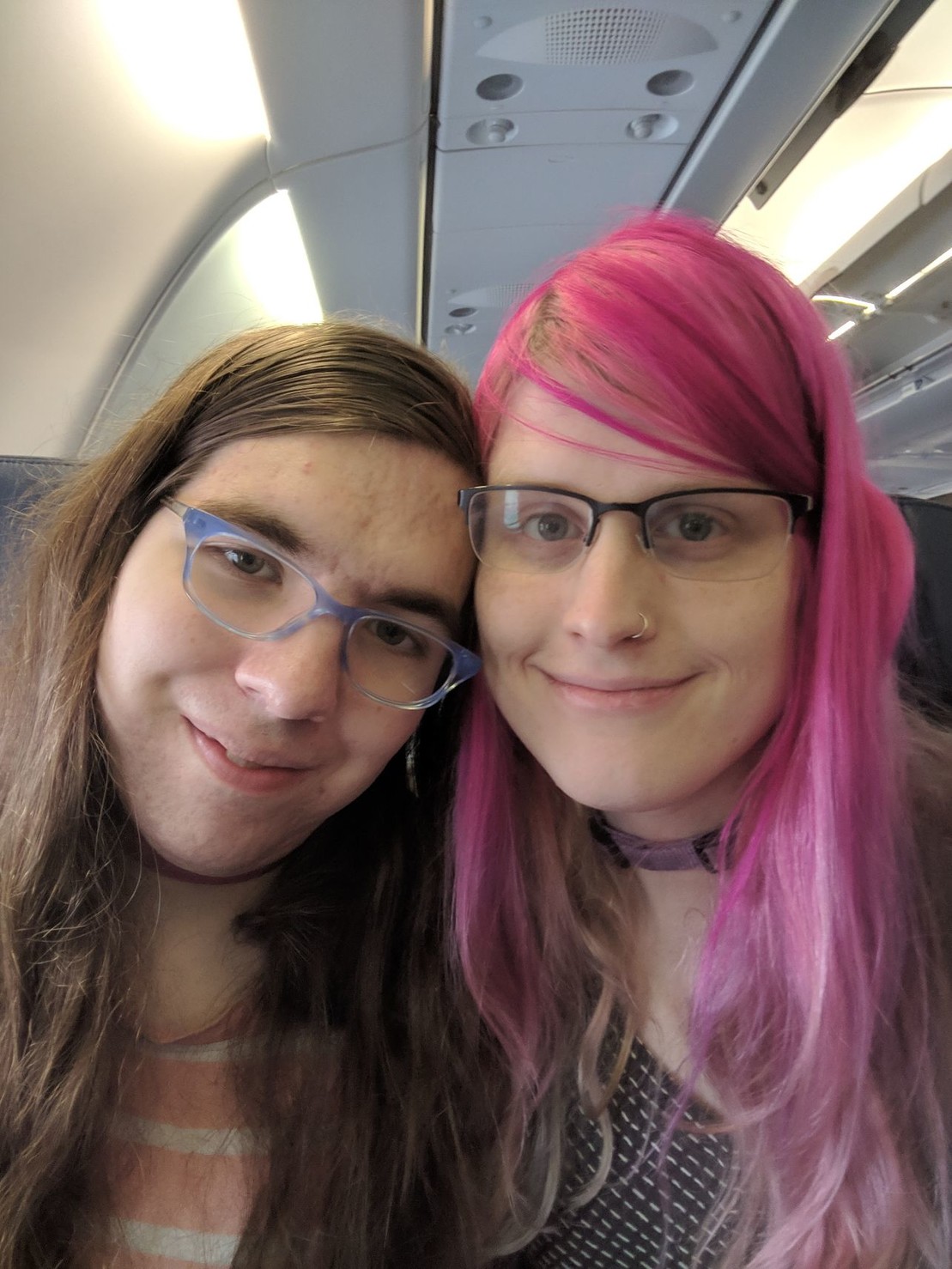 two tired but smiling women on an airplane