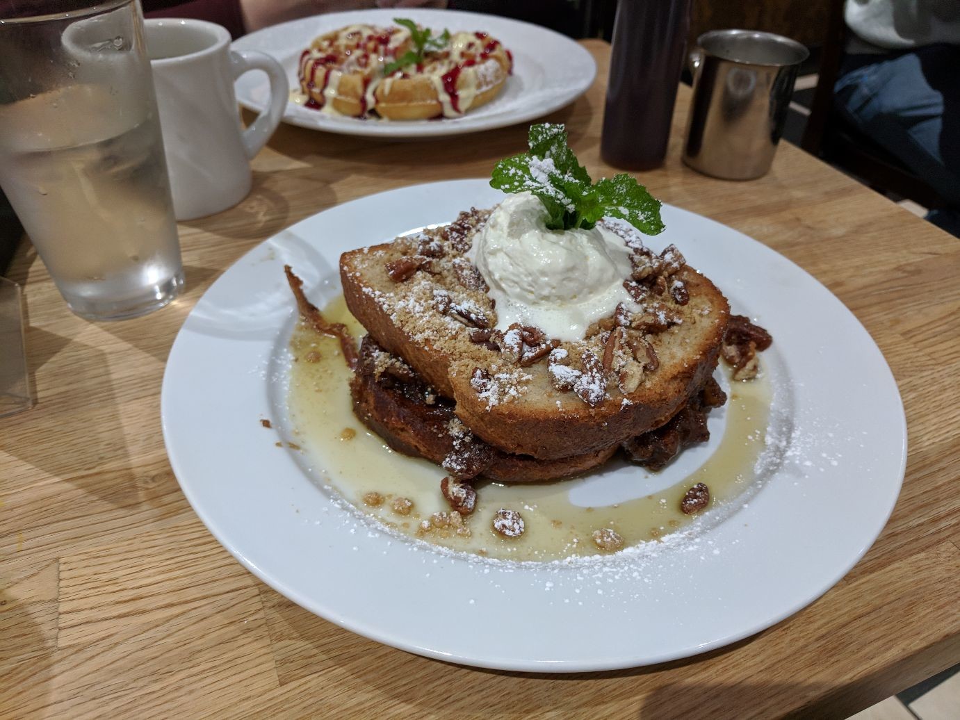 an enormous plate of French toast, stuffed with pecan pie filling and covered in whipped creme and powdered sugar
