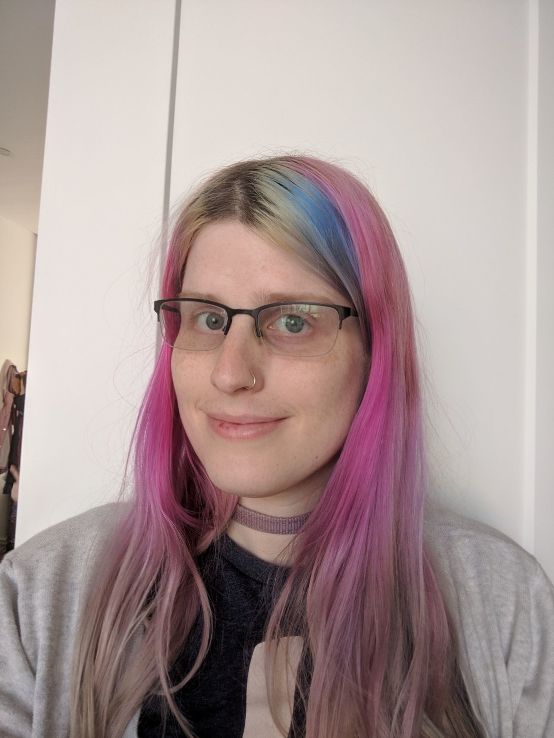 a smiling girl with pink and blue hair