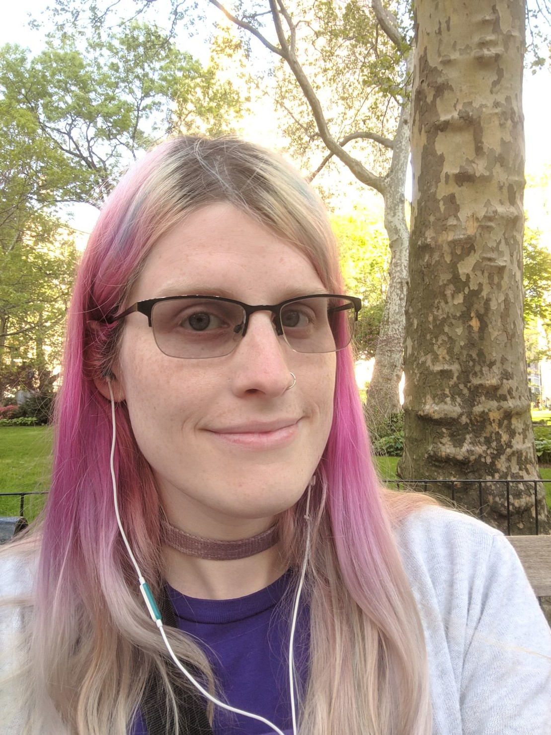 the author sitting in a park, surrounded by greenery.