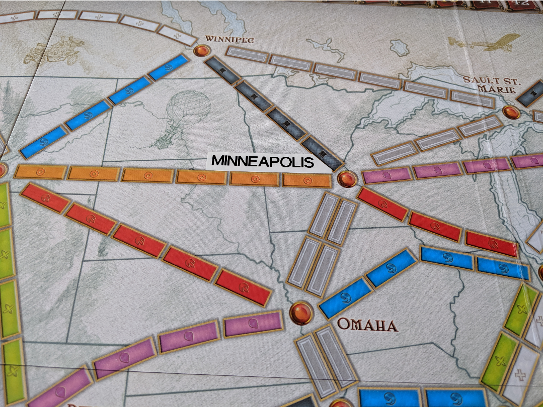 a white label Minneapolis stuck to a Ticket to Ride board
