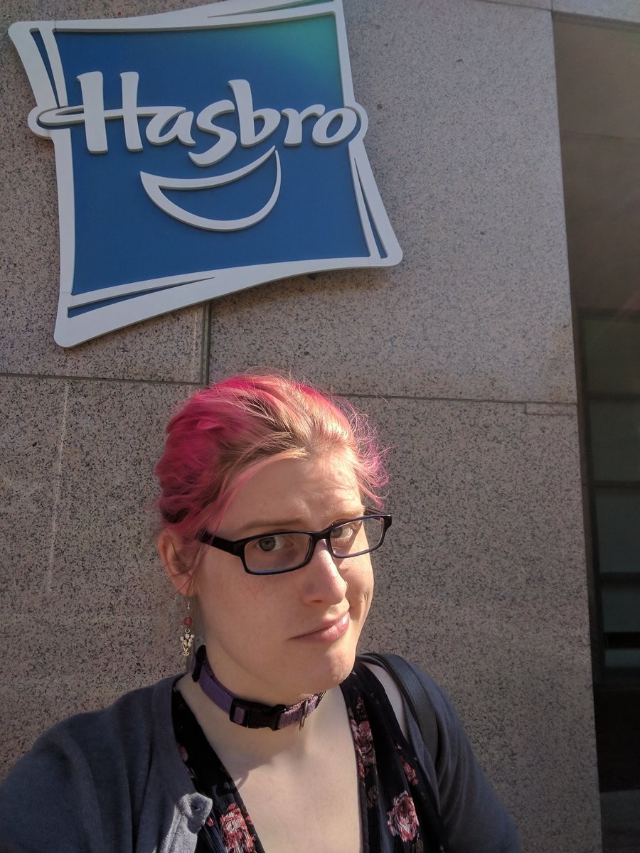 A skeptical women in front of hasbro HQ