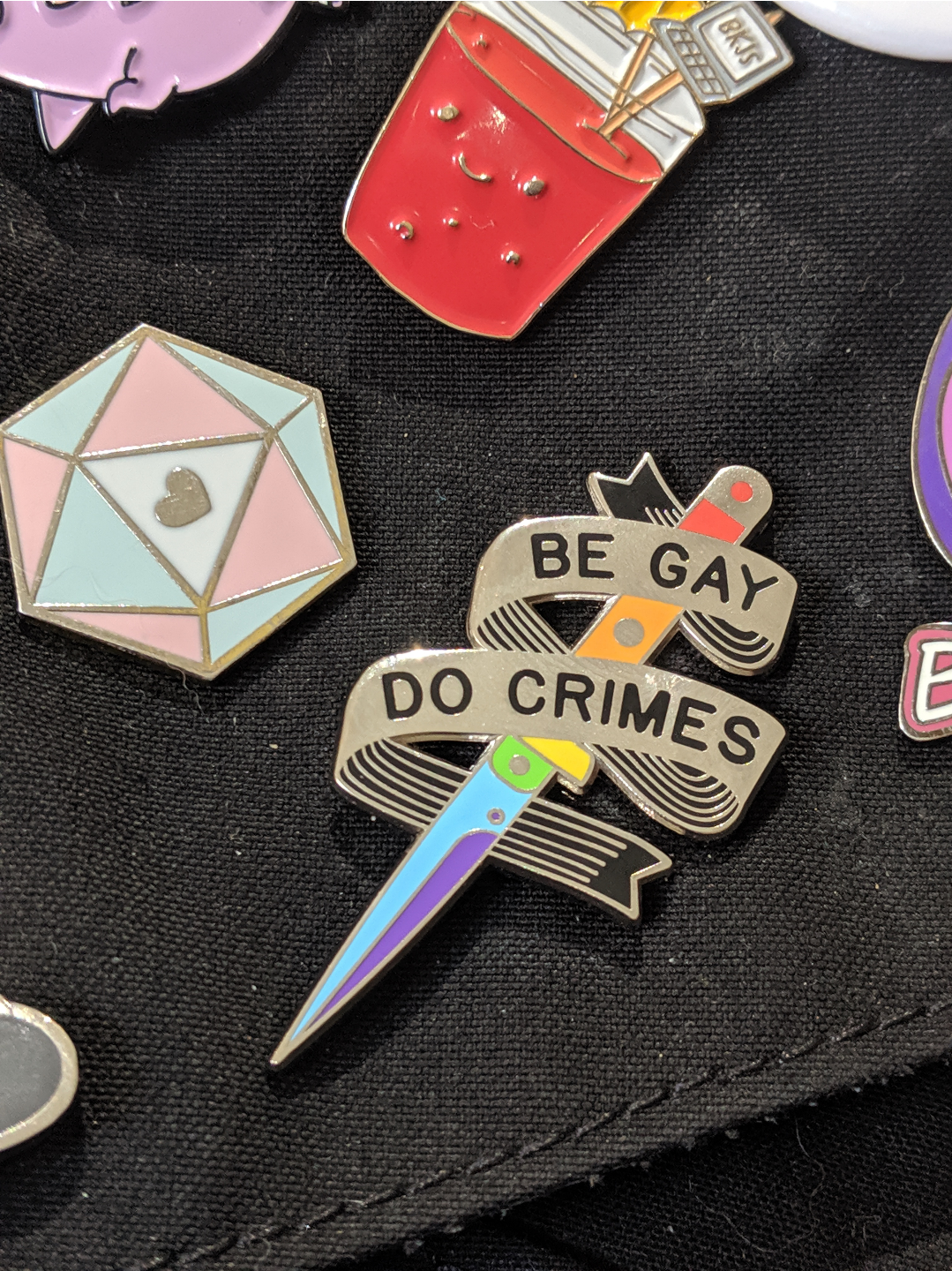 a rainbow knife with BE GAY DO CRIMES on a ribbon around it