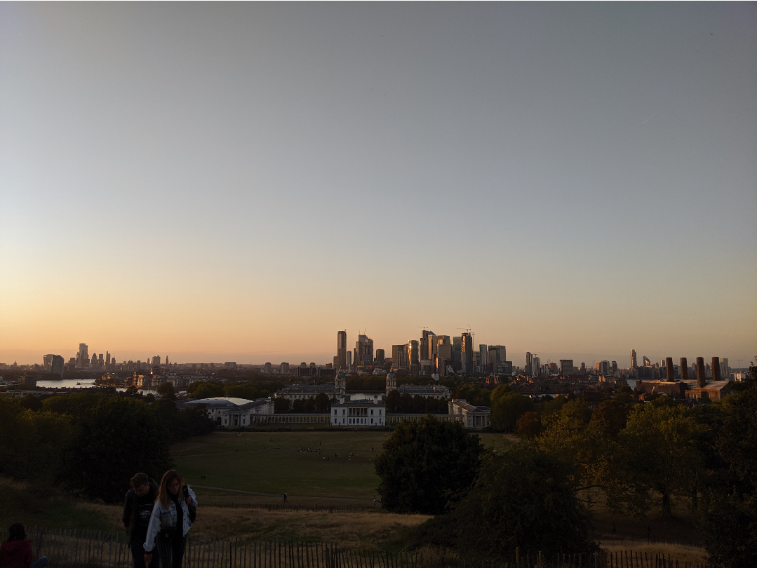 a view from the top of Greenwich park, showing canary wharf's skyscrapers and downtown London in the distance