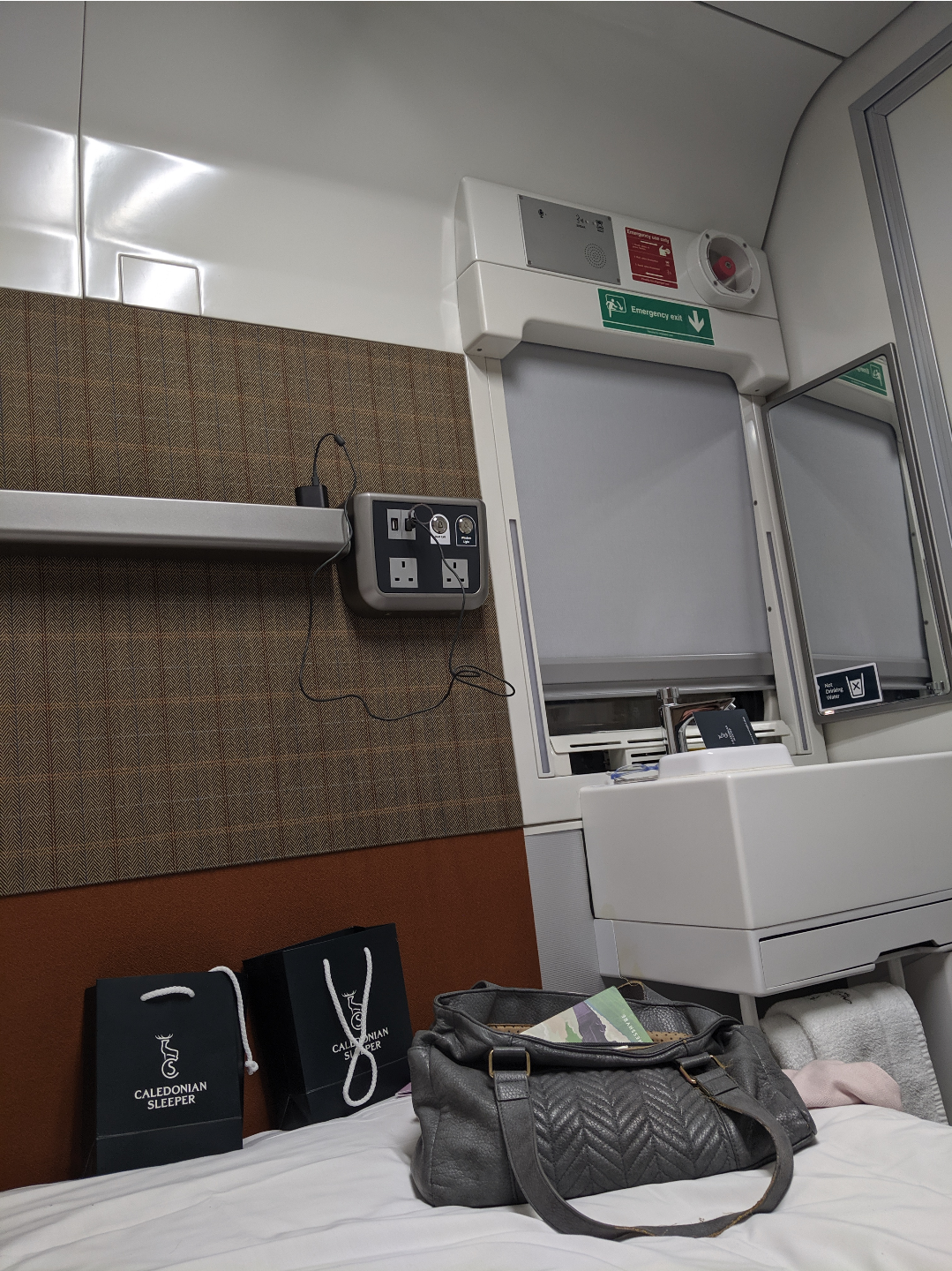 the interior of a sleeper cabin showing the bed and a small washbasin