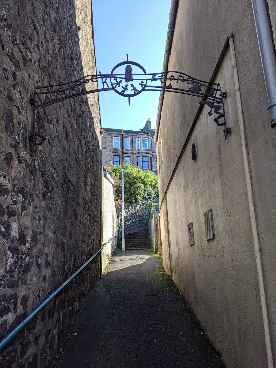 An alley between two buildings with a staircase at the year