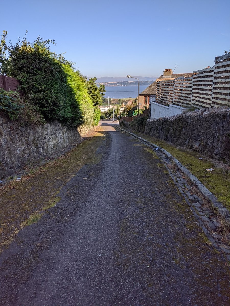 A mossy path sloping downwards towards a bay