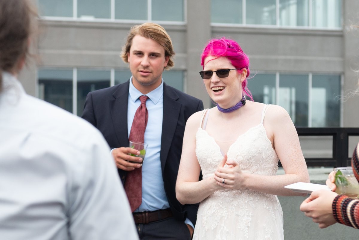 A pink haired bride wearing sunglasses