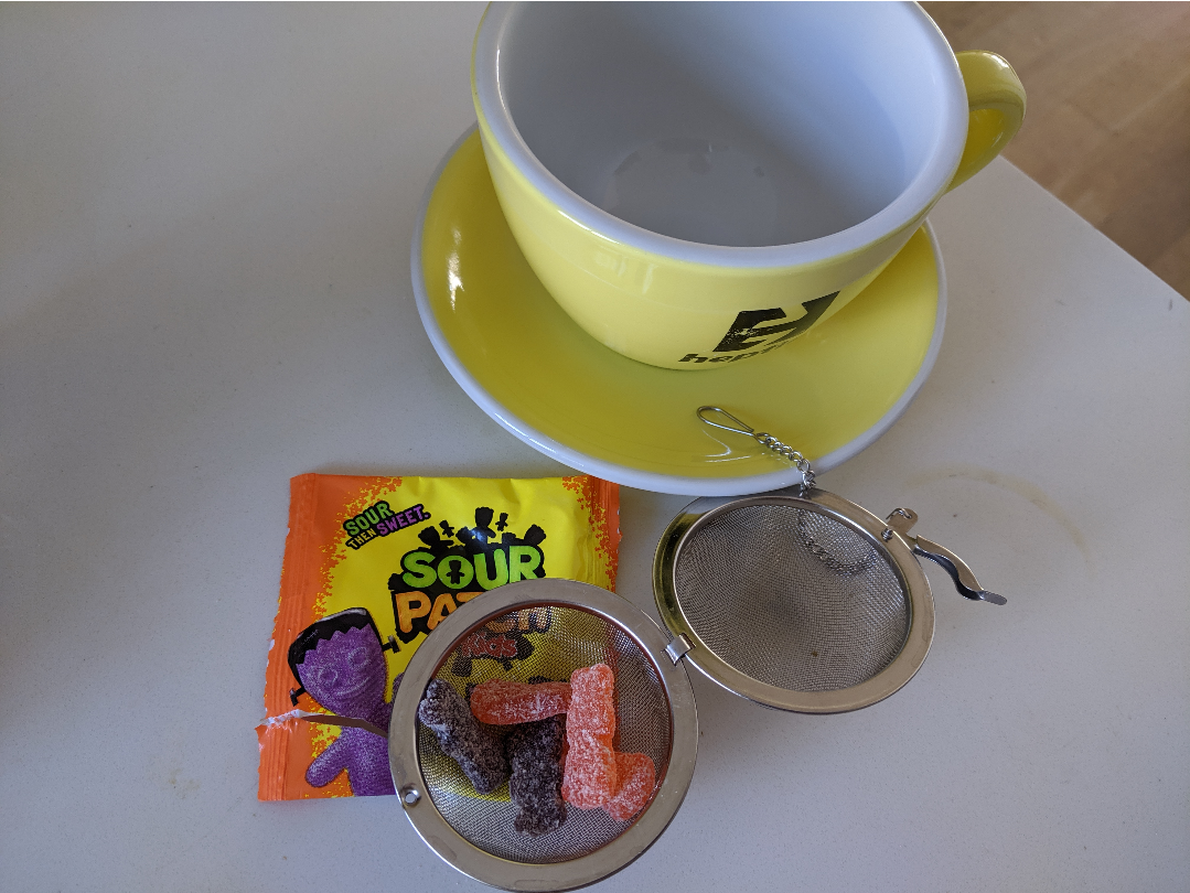 a metal tea ball filled with sour patch kids