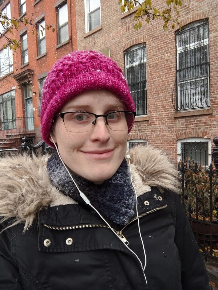 A selfie of me, wearing a pink hat, with snow all around me
