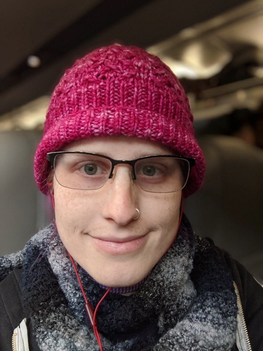 A selfie of me on a train wearing a pink hat
