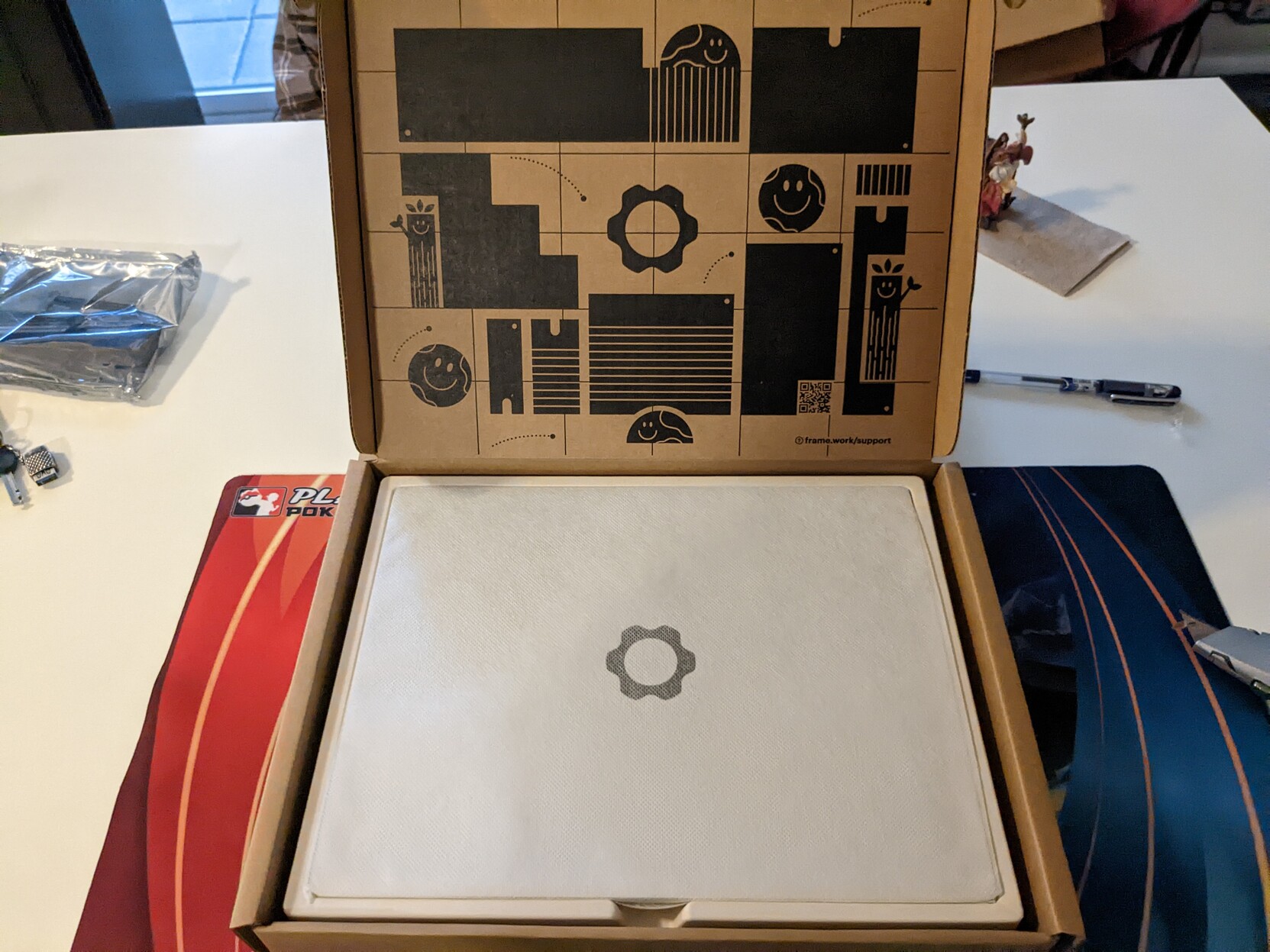The box open, with a black charming design and a laptop covered in white