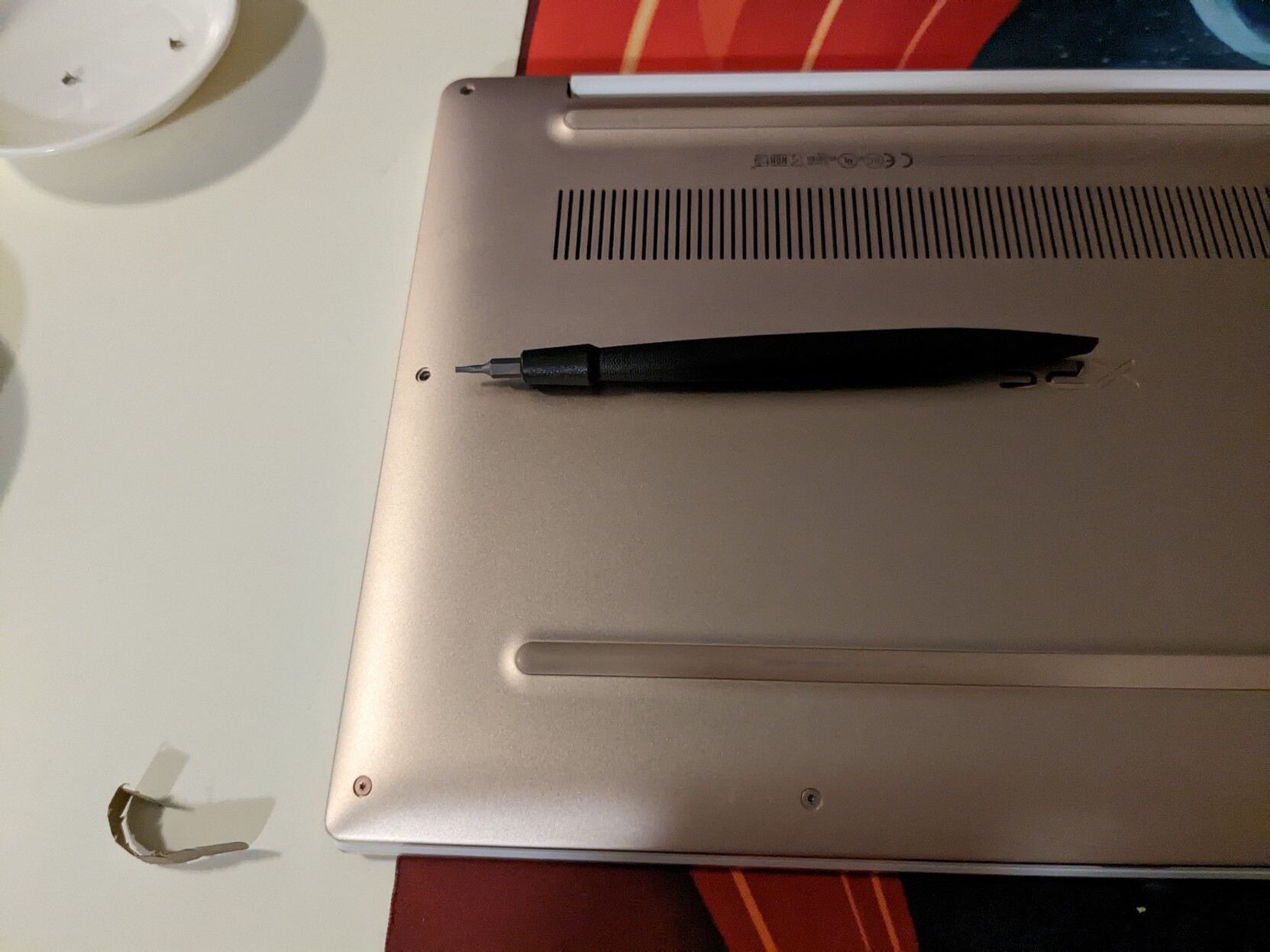 A plastic screwdriver resting on a laptop
